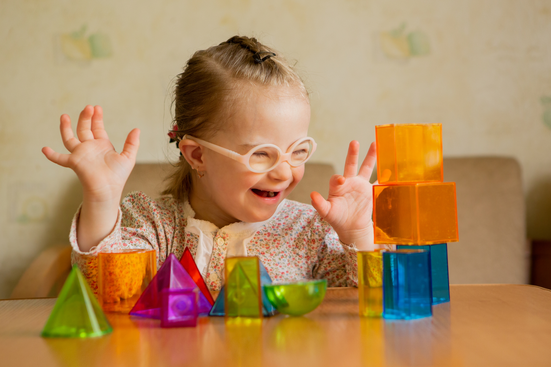 A girl with Down's syndrome lays out geometric shapes A girl with Down's syndrome lays out geometric shapes at home